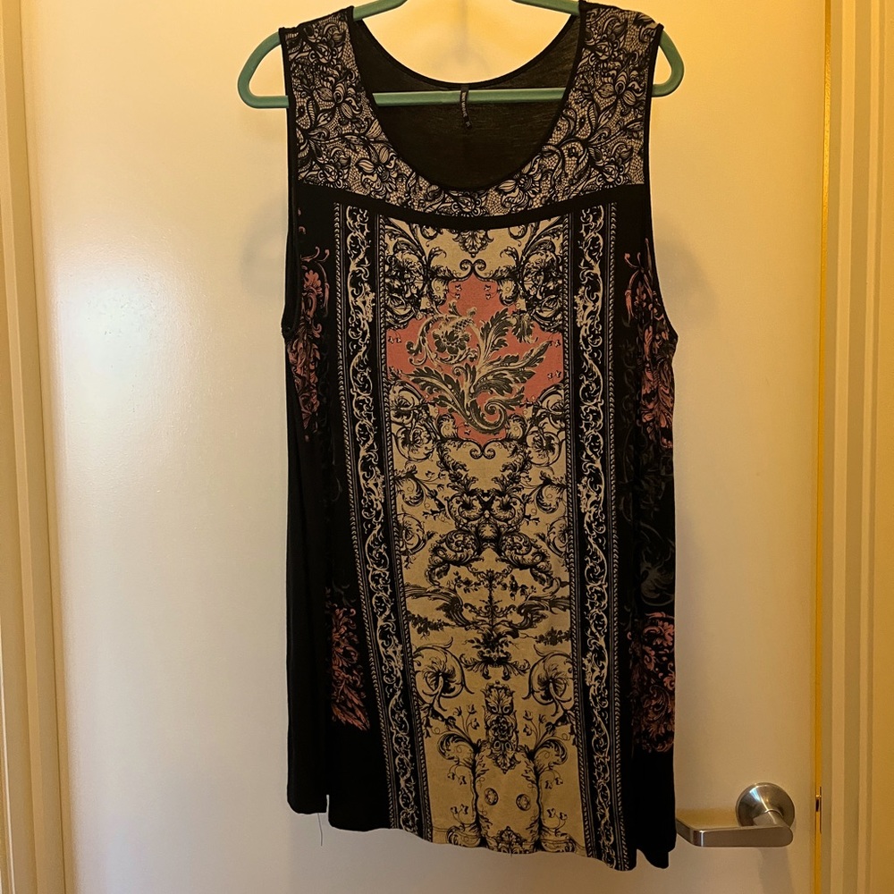 Sleeveless tunic with small black embellishments.